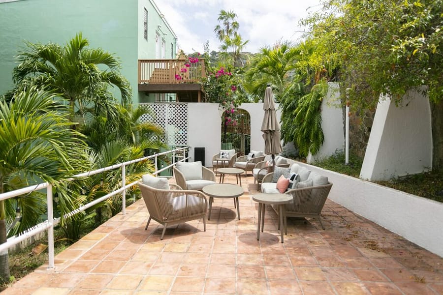 Shaded terrace lounge seating among palms at The Mary Anne, a hotel in Charlotte Amalie, St. Thomas